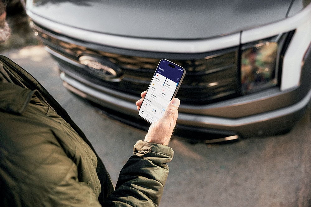 Muž dívající se na smartphone před vozem Ford Ranger.