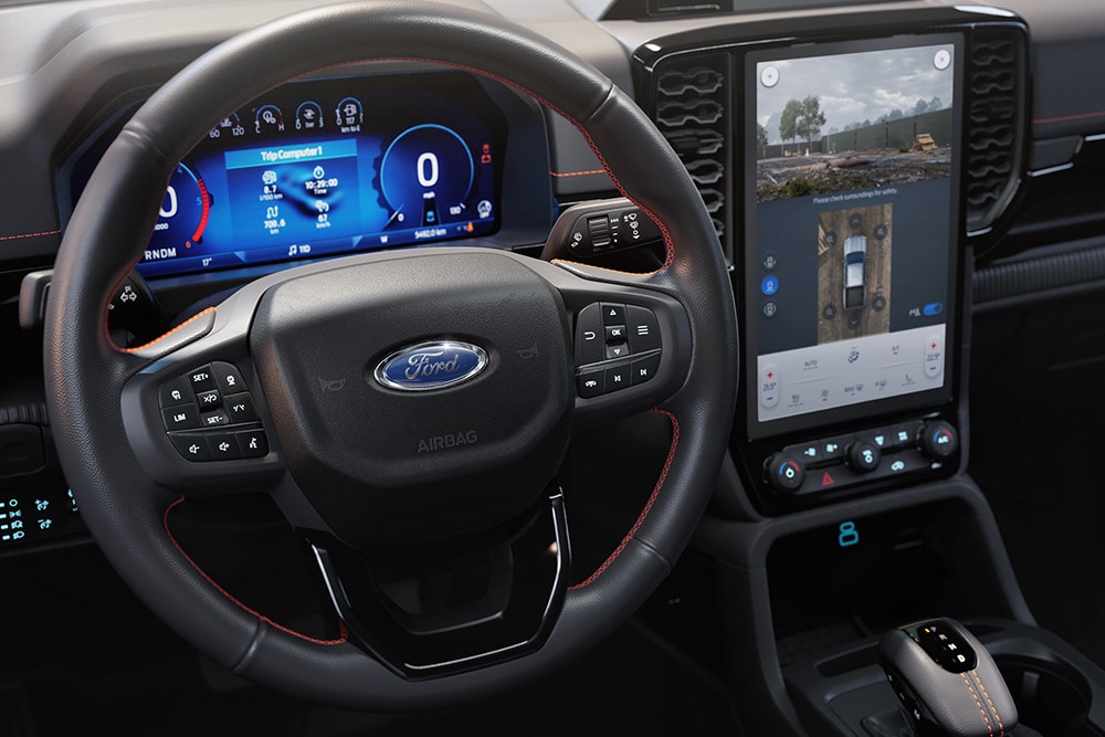 Pohled na volant a středovou konzolu systému SYNC™ 4 s 12palcovou dotykovou obrazovkou v interiéru vozu Ford Ranger Wildtrak.
