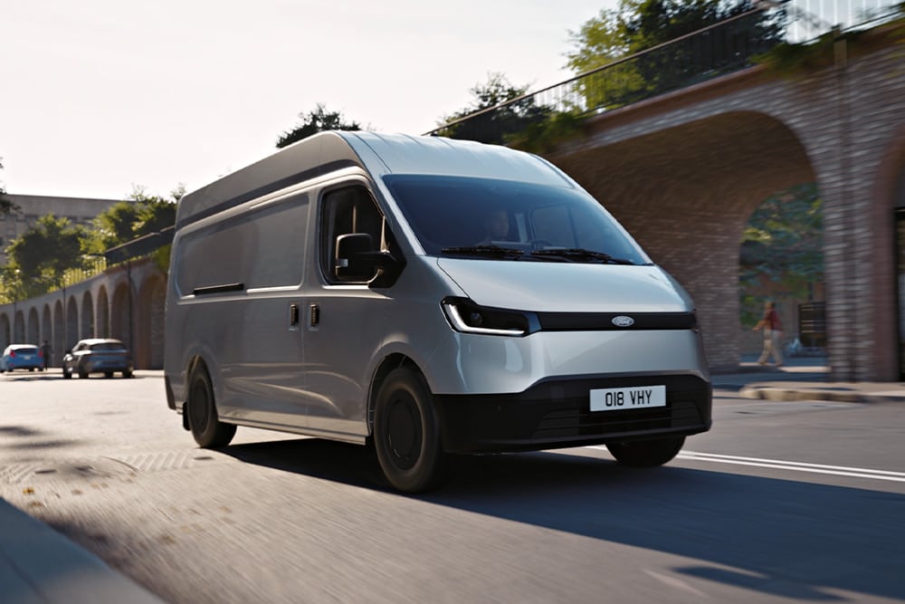 Bílá dodávka Ford Transit City® L1H1 jedoucí po městské ulici.