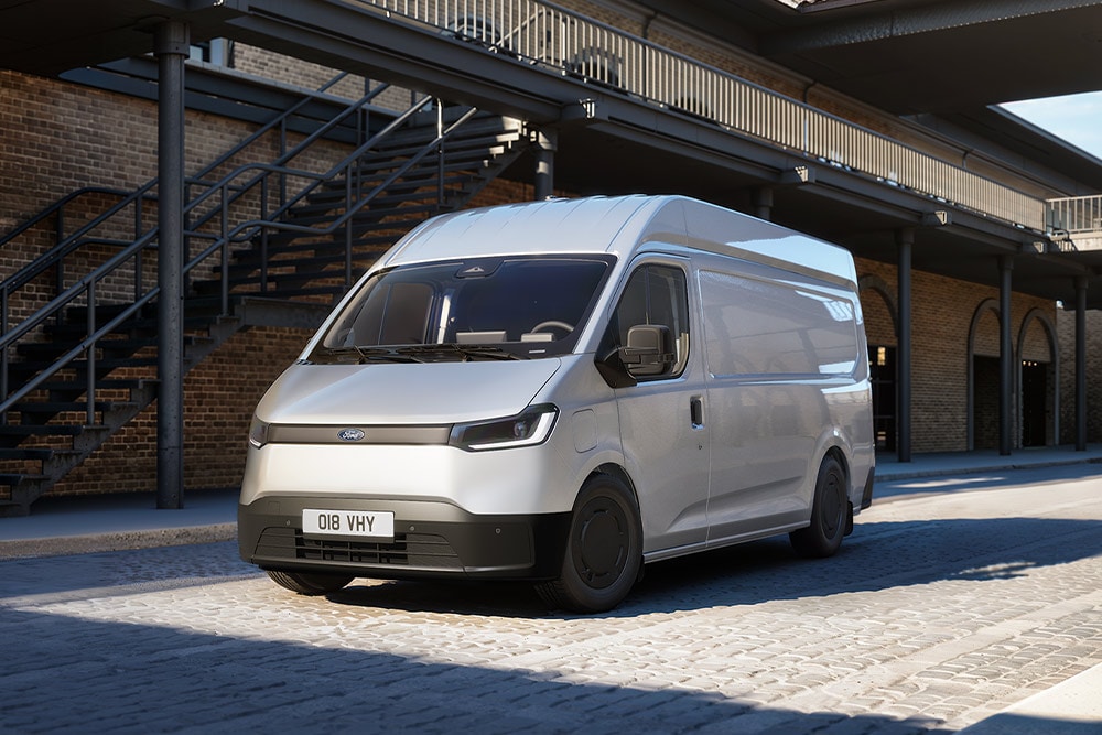 Bílá dodávka Ford Transit City® L2H2 zaparkovaná před cihlovou budovou.