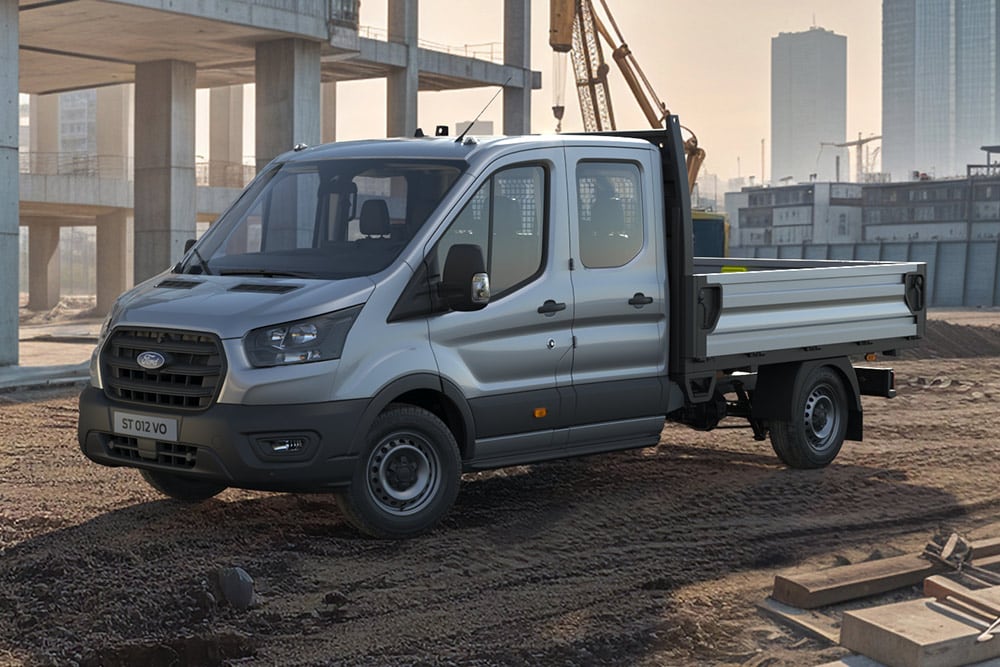 Bílý Ford E-Transit podvozek zaparkovaný na staveništi.