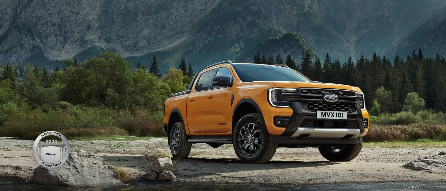 3/4 přední pohled na Ford Ranger Wildtrak zaparkovaný v blízkosti hor
