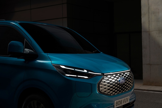 Detailní záběr na modrou elektrickou dodávku Ford E-Transit Custom.