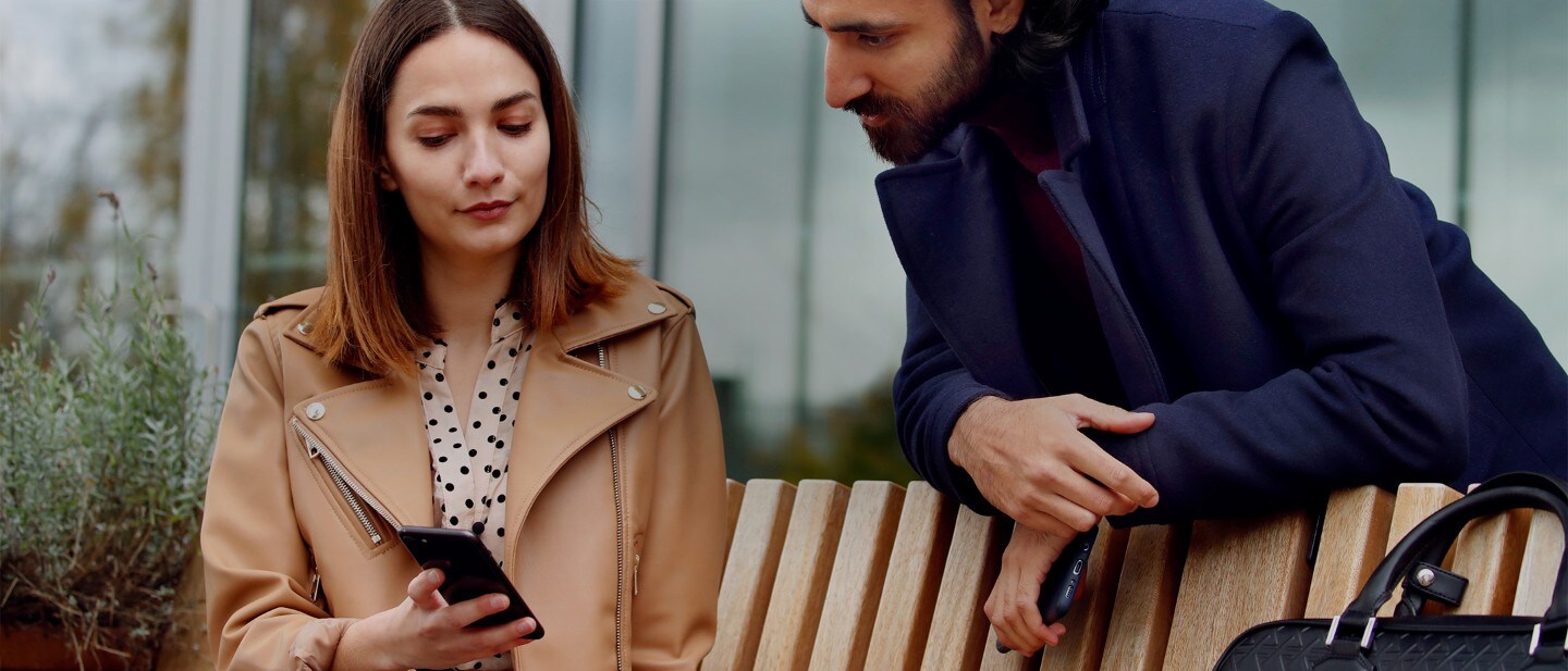 Woman with mobile sitting with man next to